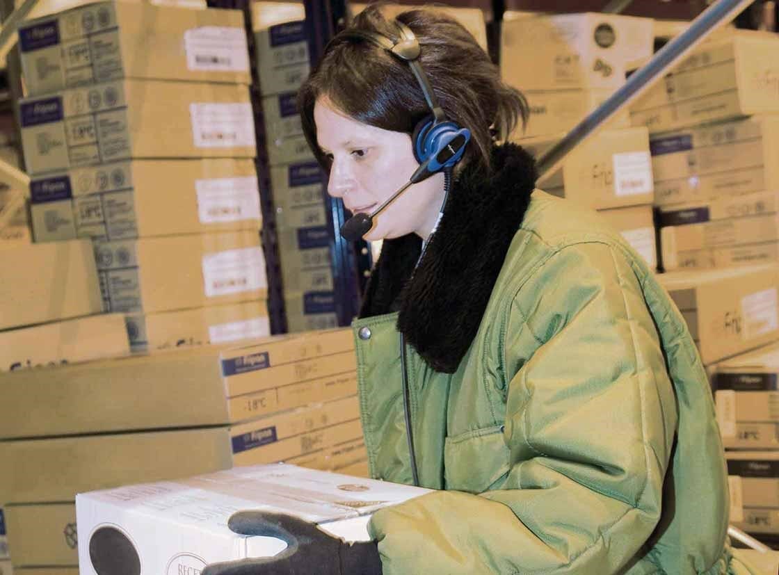 Um operador realiza as tarefas de preparação de pedidos com um sistema de voice picking