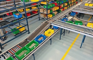 Um circuito de transportadores de caixas liga as estantes às estações de picking